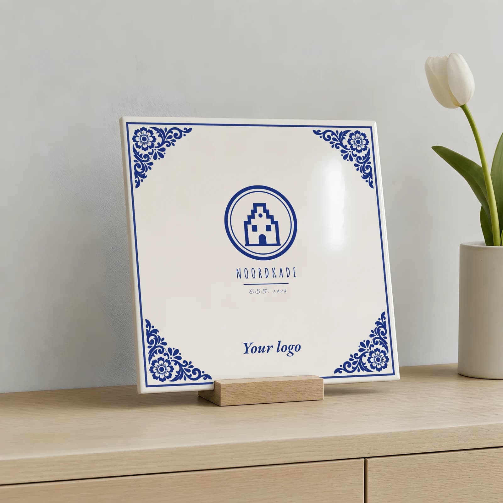 Delft Blue logo tile in a wooden holder on a sideboard